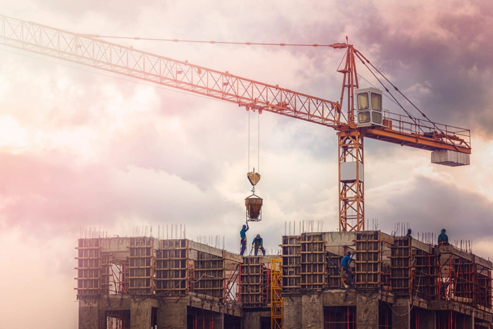 A crane on a construction site with a cloudy sky.