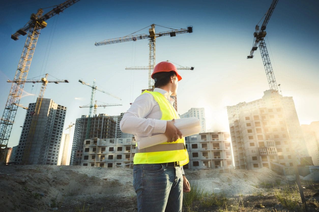 A construction worker standing in front of a construction site.