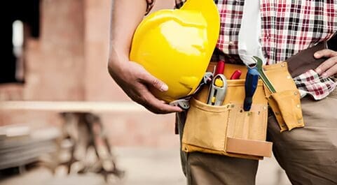 A man holding yellow hard hat in his hand.